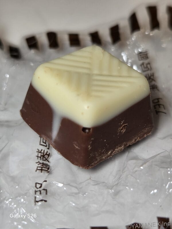 Galaxy S26 カメラ 包装紙を開封した小さなチョコレート